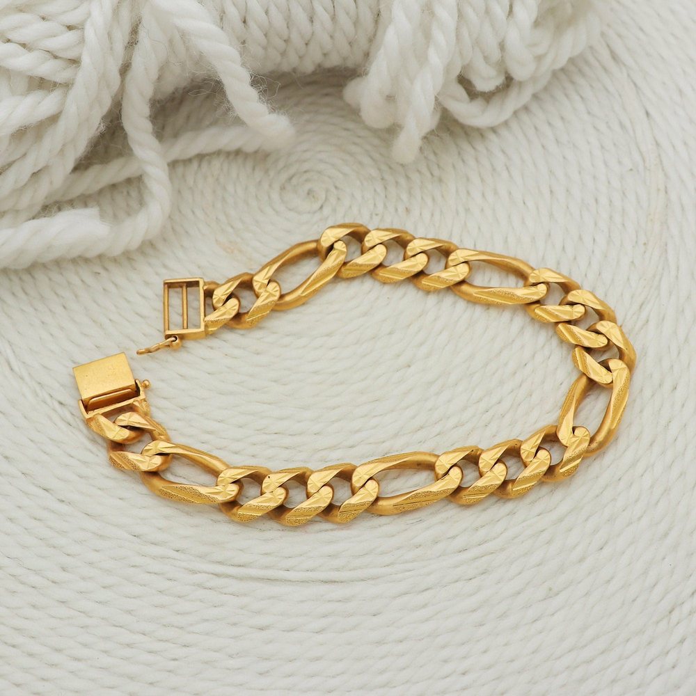 Restored gold figaro bracelet on marble